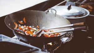 Stir Fry vegetables in a wok on a gas stove.